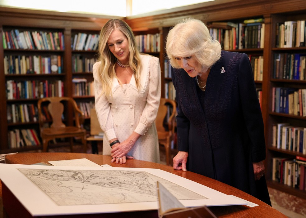 Sarah Jessica Parker e a Rainha Camilla, do Reino Unido, examinam artefatos em exibição durante um evento literário na Biblioteca Pública de Nova York — Foto: Chris Jackson/Pool via REUTERS