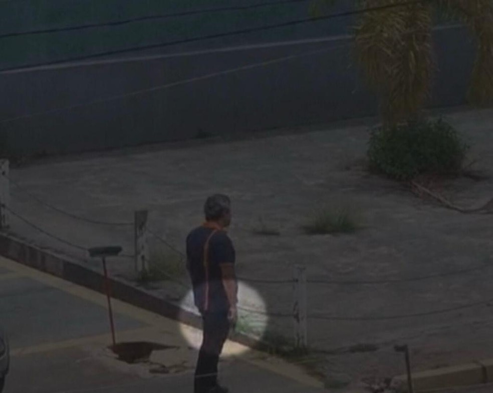 Policial civil do DF armado após atirar em funcionários de empresa de telefonia que trabalhavam na rua, em Vicente Pires — Foto: TV Globo/Reprodução