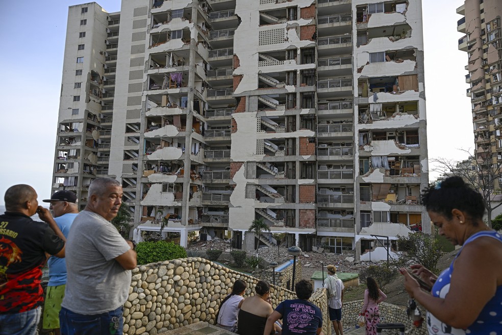 Pessoas observam os pr&eacute;dios de apartamentos danificados ap&oacute;s um terremoto em Catia La Mar, estado de La Guaira &mdash; Foto: FEDERICO PARRA / AFP