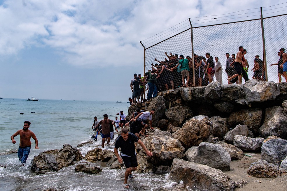 Migrantes entram em Ceuta, enclave espanhol no norte da África, vindos do Marrocos. — Foto: Antonio Sempere / AP