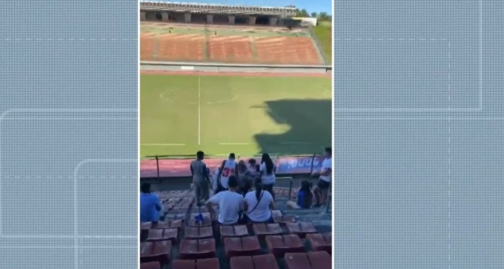 Um vídeo flagrou o momento que um homem, sentado, recebe vários murros de uma mulher, e chutes de um outro homem. — Foto: Reprodução/TV Bahia