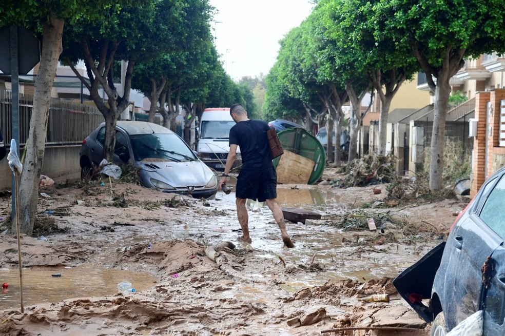 Homem caminha sobre lama em Picanya, perto de Valencia, após região ser atingida por chuvas torrenciais, em 30 de setembro de 2024. — Foto: Jose Jordan/ AFP