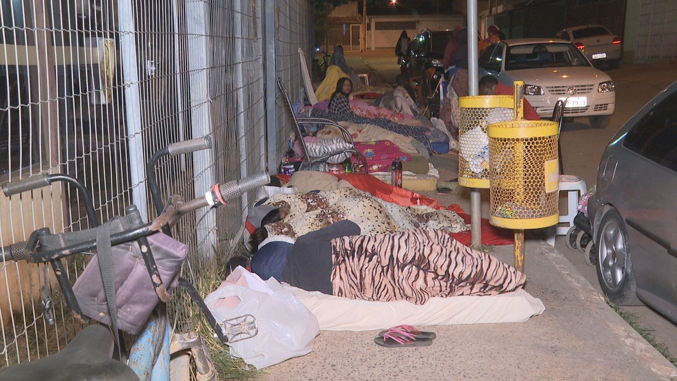 Pessoas dormem em frente à unidades do Cras para conseguir senhas de atendimento — Foto: TV Globo