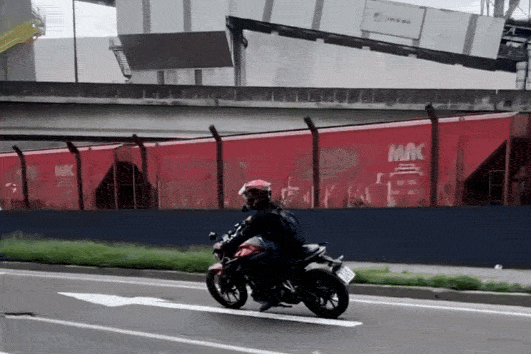 Motociclista cai após passar por buraco na Avenida Perimetral em Santos, SP; VÍDEO