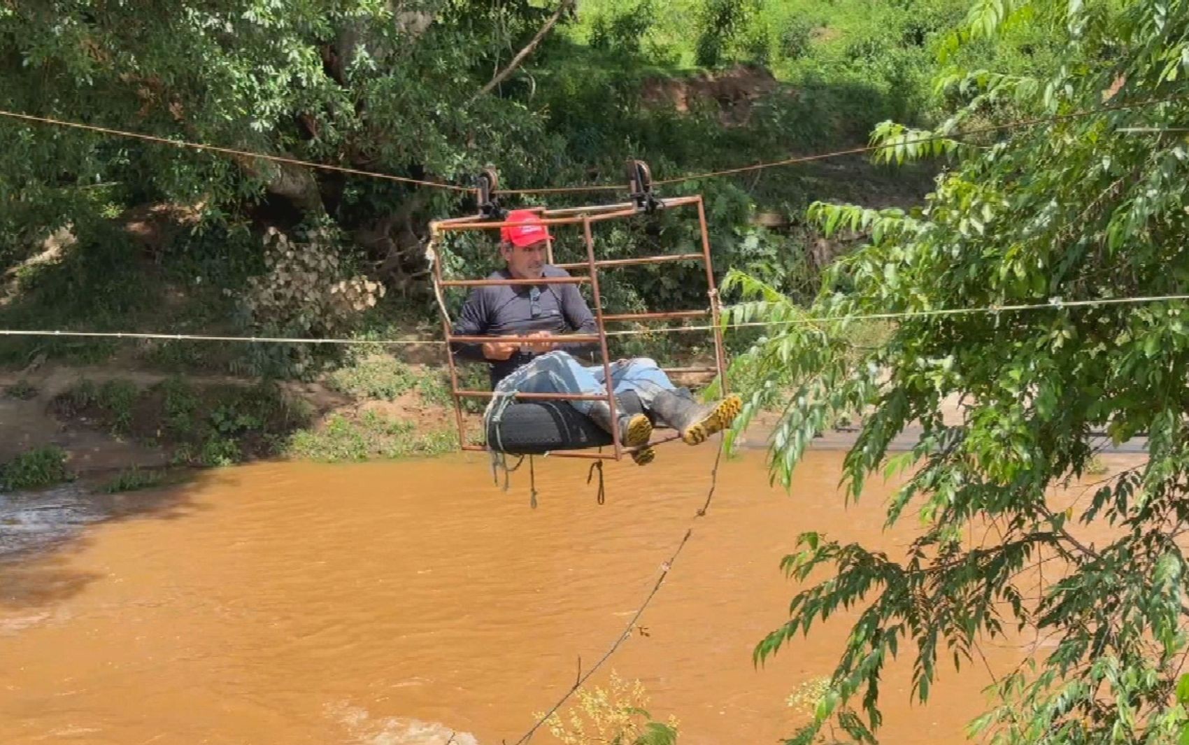 Ponte entre duas cidades goianas é arrastada pela chuva e moradores improvisam tirolesa