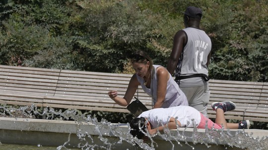Sombra, fontes e sorvete: turistas e europeus buscam alternativas para se refrescar em meio à onda de calor; FOTOS - Com temperatura próxima dos 40ºC, a França emitiu um alerta vermelho e reduziu o horário de acesso à Torre Eiffel. Cidades da Itália, Espanha e Portugal também registraram altas temperaturas.