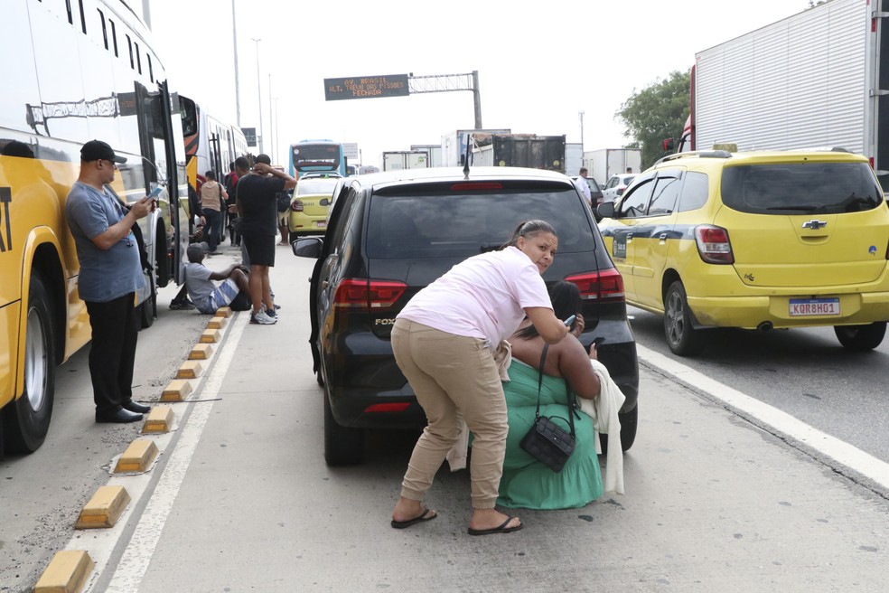 Pessoas se protegem de tiroteio na Avenida Brasil após confronto entre policiais e traficantes  — Foto: José Lucena/The News 2/Estadão Conteúdo
