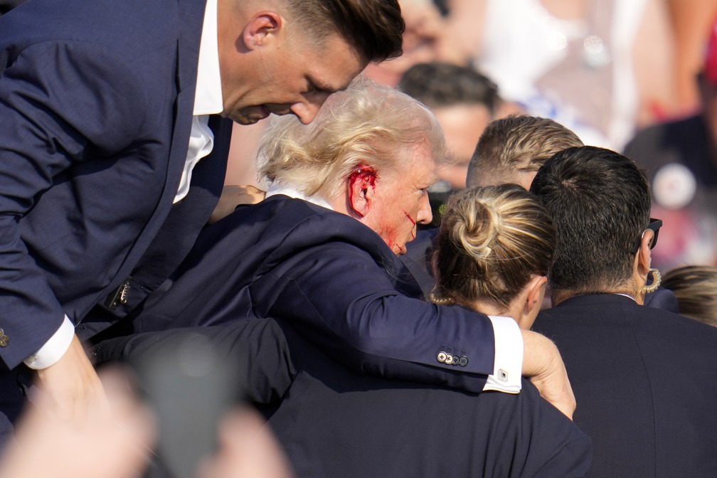 Donald Trump aparece com ferimento na orelha após tiros em comício do ex-presidente americano, na Pensilvânia — Foto: AP Photo/Gene J. Puskar