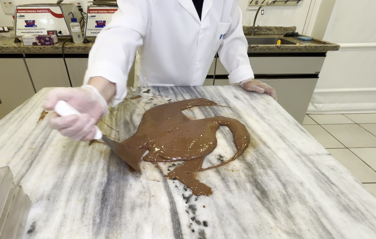 O que é temperagem? Entenda a técnica que reorganiza moléculas do chocolate e deixa o ovo de Páscoa firme e brilhante