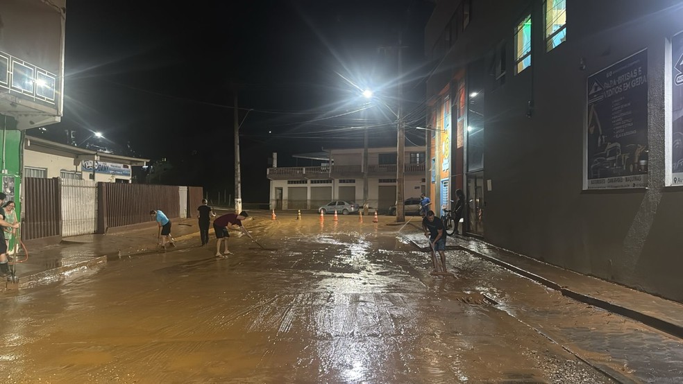 Moradores passaram o começo da noite deste domingo de Páscoa limpando a sujeira deixada pelo alagamento — Foto: RPC