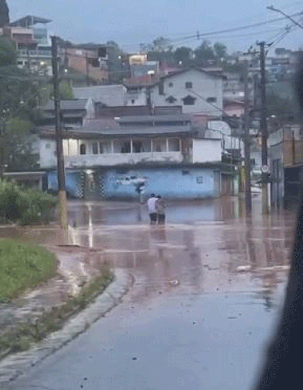 Homem e mulher tentam atravessar rua alagada em Rio Grande da Serra — Foto: Divulgação/Portal Rio Grande da Serra 24 horas
