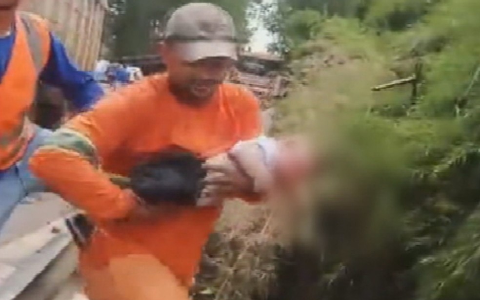 Homem resgata criança que ficou ferida em acidente com 18 veículos e 4 mortos na BR-414, em Anápolis, Goiás — Foto: Reprodução/TV Anhanguera