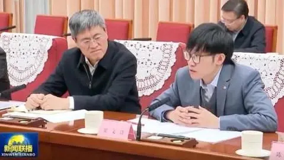 O fundador da DeepSeek, Liang Wenfung (à direita), em uma recente reunião do governo da China — Foto: CCTV