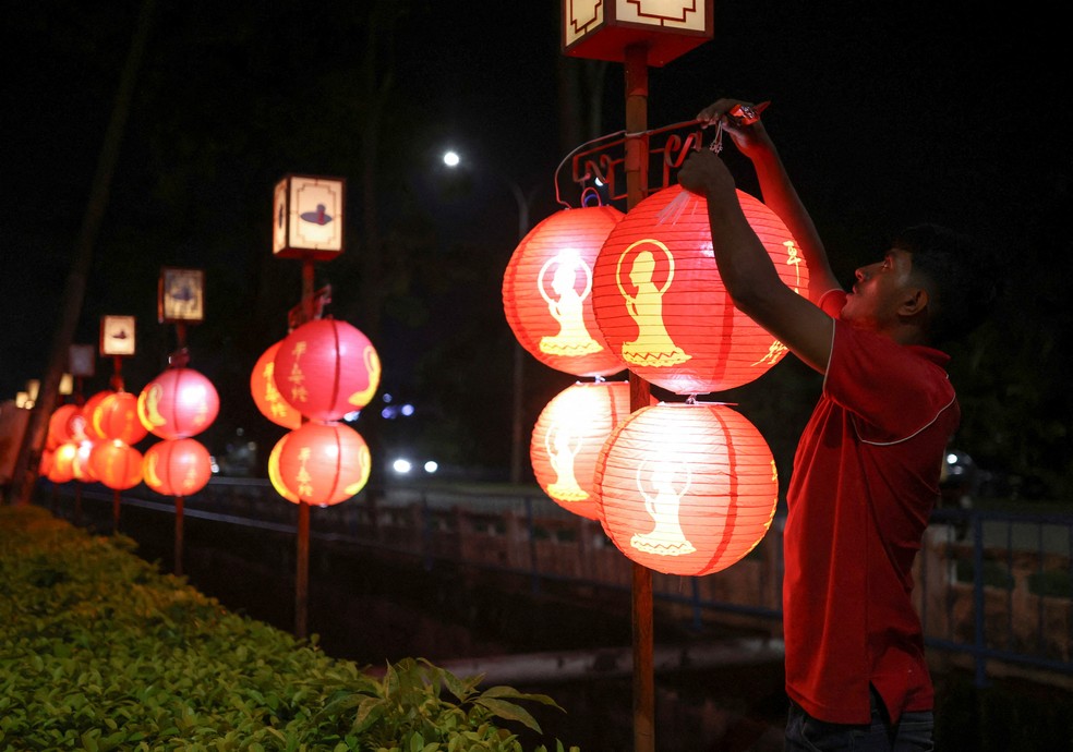 Homem arruma lanterna para o Ano Novo Chinês — Foto: Reuters