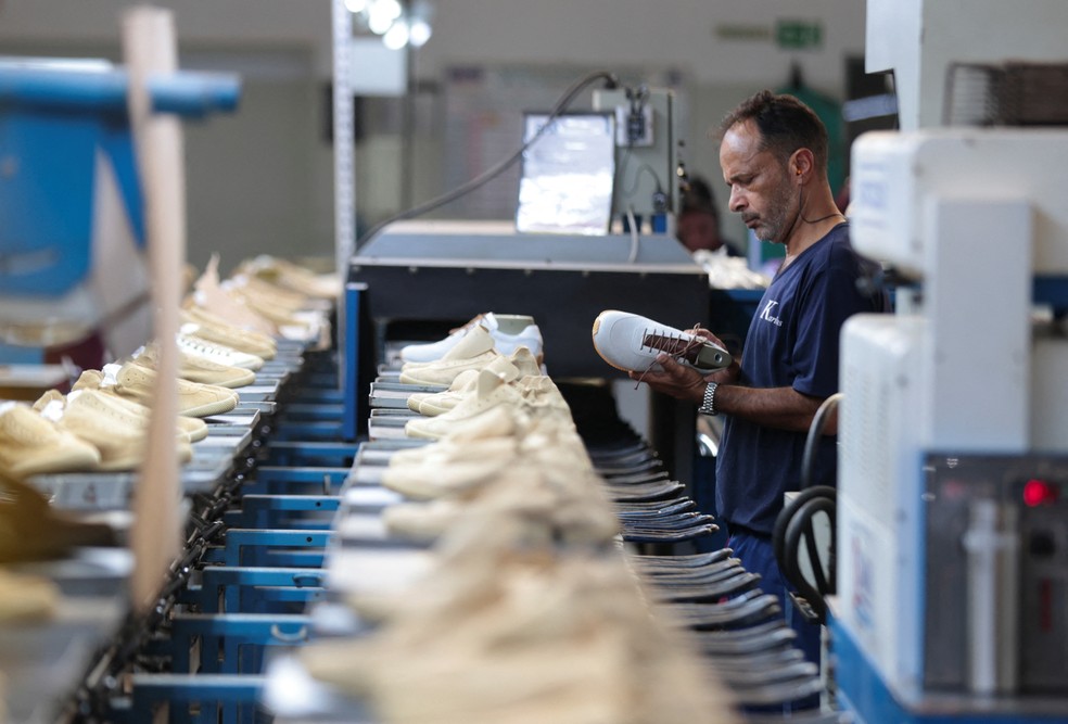 Um funcionário inspeciona um sapato em uma linha de produção da fabricante brasileira de calçados Kissol, em meio à imposição de novas tarifas americanas sobre diversos produtos brasileiros, incluindo a indústria calçadista, que tem os EUA como seu principal mercado externo. — Foto: Joel Silva/Reuters