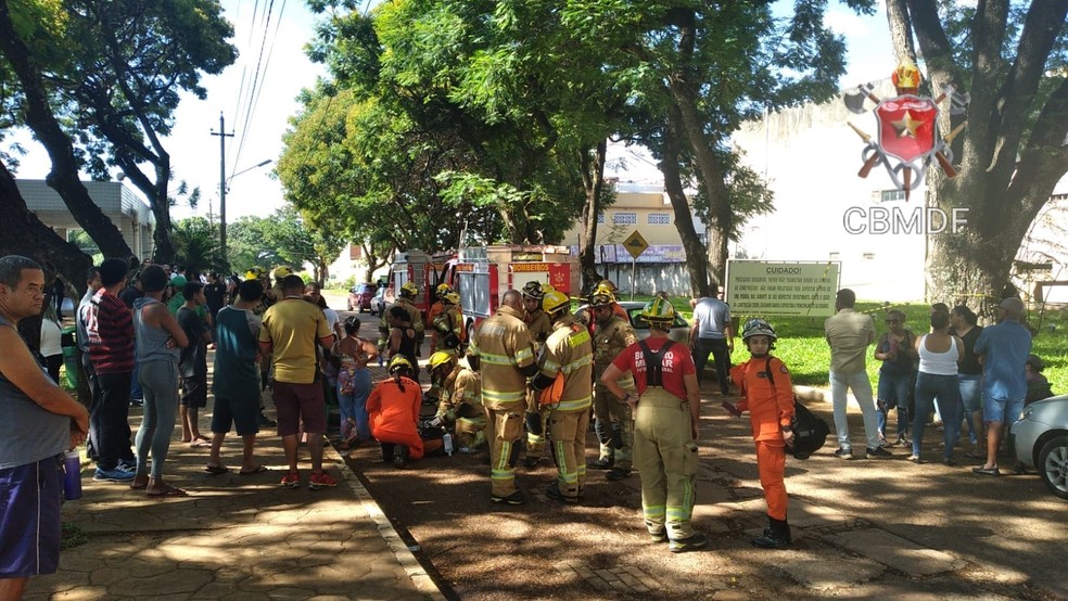 Bombeiros socorrem pessoas que caíram em cova de cemitério, em terreno que cedeu durante enterro, no DF — Foto: CBMDF/Divulgação