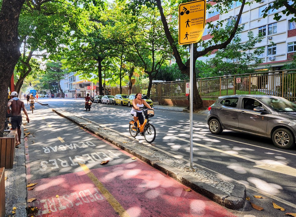 Mesmo com a ciclovia vazia, ciclista prefere se arriscar no meio dos carros — Foto: Raoni Alves / g1 Rio