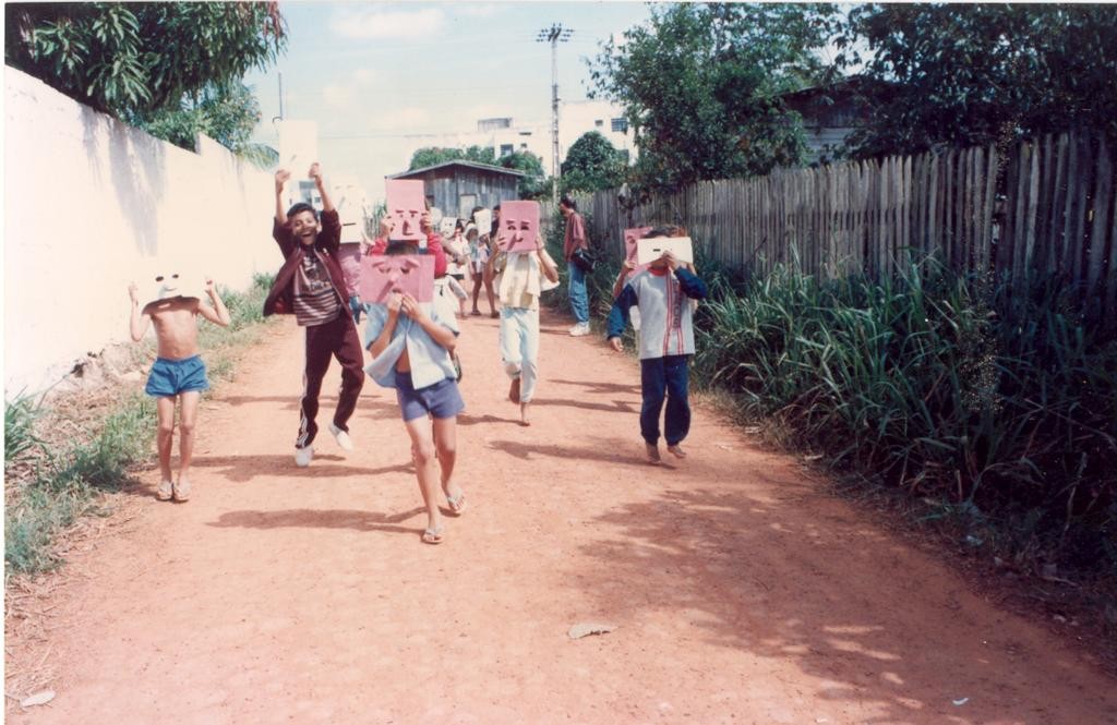 Crianças da escola de 1° Grau Ione Portela da Costa Casas, em uma das ruas do bairro Nova Estação - 1993 usando máscaras de papelão.