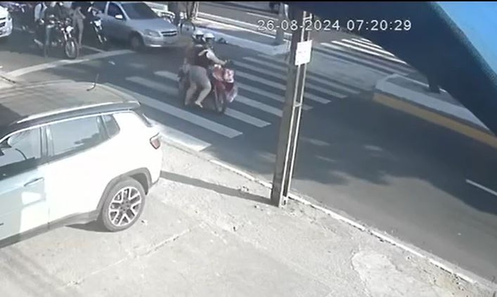 Mesmo com faixa de pedestres a condutora da moto não freia para os pedestres passarem a via. — Foto: Reprodução/TV Verdes Mares