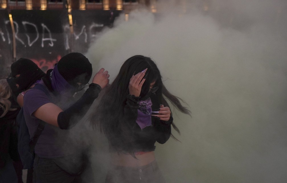 Manifestantes se protegem de fuma&ccedil;a em confronto com a pol&iacute;cia durante manifesta&ccedil;&atilde;o pelo Dia Internacional da Mulher na Cidade do M&eacute;xico, em 8 de mar&ccedil;o de 2024. &mdash; Foto: Aurea del Rosario/ AP