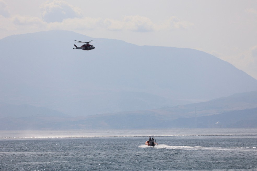 Barco e helicóptero participam de buscas por passageiros de iate que naufragou ao ser atingido por um tornado na costa da Sicilia, no su da Itália, em 19 de agosto de 2024 — Foto: Igor Petyx/ Reuters