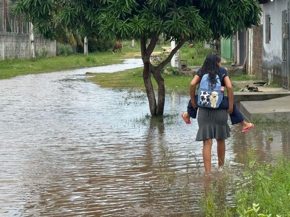 Mãe leva criança nas costas em rua da comunidade Cavaco Chinês, na Zona Norte de Natal — Foto: Sérgio Henrique Santos/Inter TV Cabugi