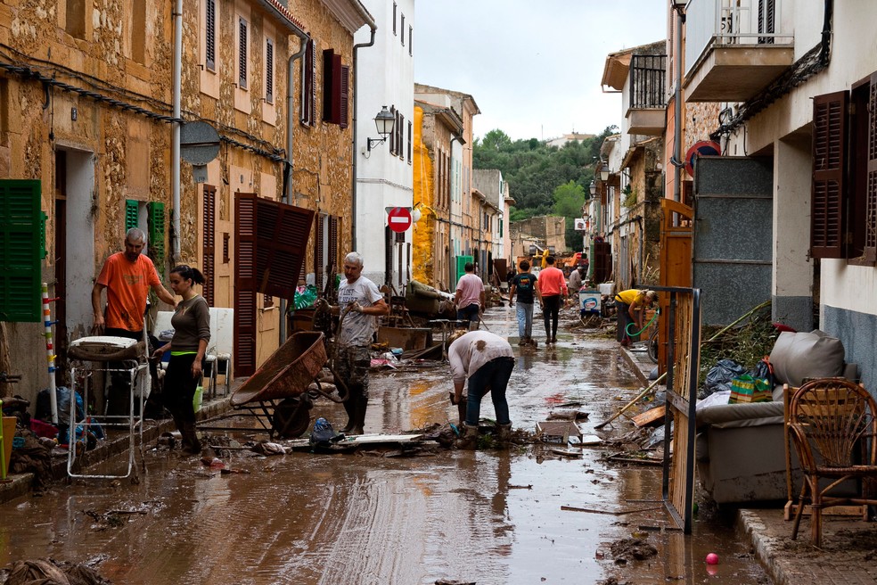 Moradores de Sant Llorenc, em Mallorca, na Espanha, limpam sujeira deixada pela forte chuva que atingiu a ilha turística  — Foto: Francisco Ubilla/ AP
