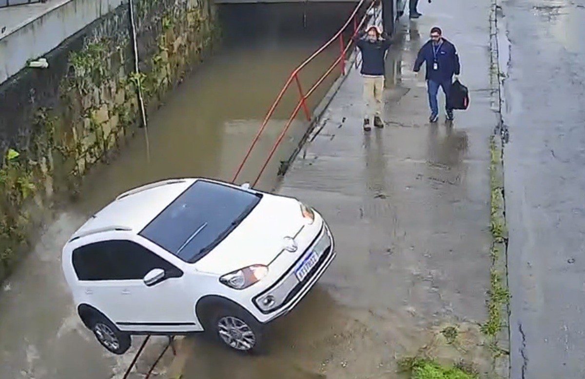 Carro sem motorista atravessa rua e cai no rio em Petrópolis; vídeo mostra reação de pedestres