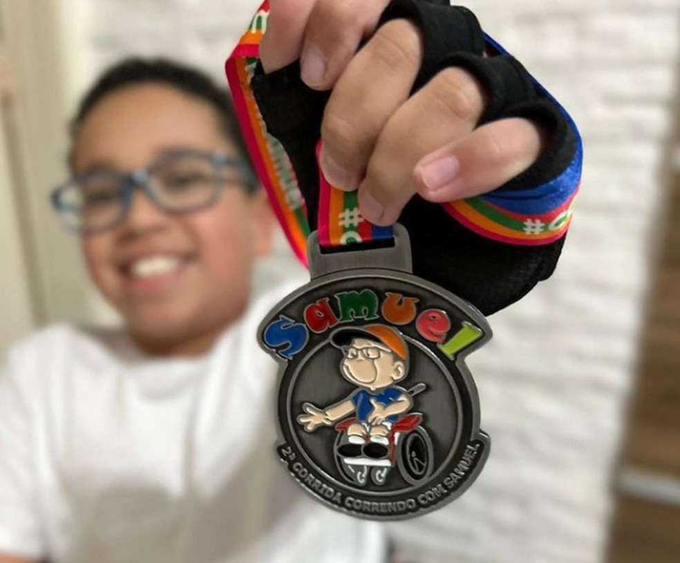 Samuel com medalha da segunda corrida feita em prol ao seu tratamento médico — Foto: Arquivo Pessoal