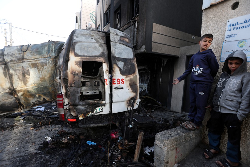 Crianças diante de veículo de TV palestina atingido por ataque de Israel na Faixa de Gaza, em 26 de dezembro de 2024. — Foto: Ramadan Abed/ Reuters
