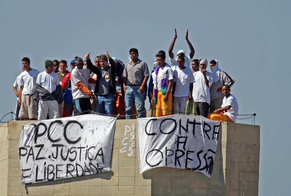 Presos fazem rebelião na Penitenciária de Junqueirópolis, em São Paulo, em 14 de maio de 2006. O motim começou às 7 da manhã, quando familiares entravam para a visita. Os rebelados subiram no telhado e prenderam faixas na caixa d´água com os dizeres: 'PCC, paz, justiça e liberdade' e 'Contra a Opressão' — Foto: Alex Silva/Estadão Conteúdo/Arquivo