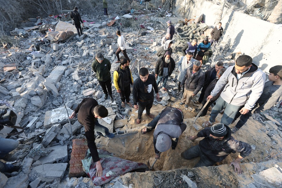 Palestinos inspecionam os danos no local de um ataque israelense a uma casa, em meio ao conflito Israel-Hamas, em Deir Al-Balah, na região central da Faixa de Gaza, em 22 de dezembro de 2024 — Foto: Ramadan Abed/Reuters