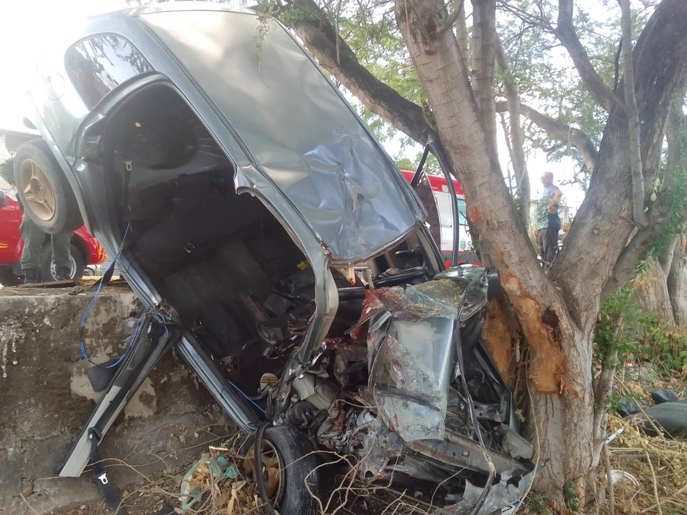 Carro ficou suspenso entre a calçada e a árvore após acidente em Maracanaú. — Foto: Corpo de Bombeiros/ Divulgação