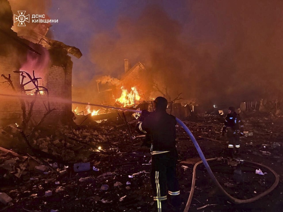 Bombeiros tentam apagar um incêndio após um ataque russo na região de Kiev em 25 de maio de 2025 — Foto: Serviço de Emergência da Ucrânia/AP
