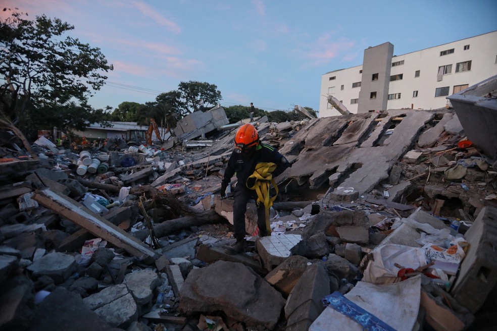Um socorrista caminha sobre os escombros um dia após o terremoto que atingiu Cali, Colômbia, na terça-feira, 11 de agosto de 2026 — Foto: Santiago Saldarriaga/AP
