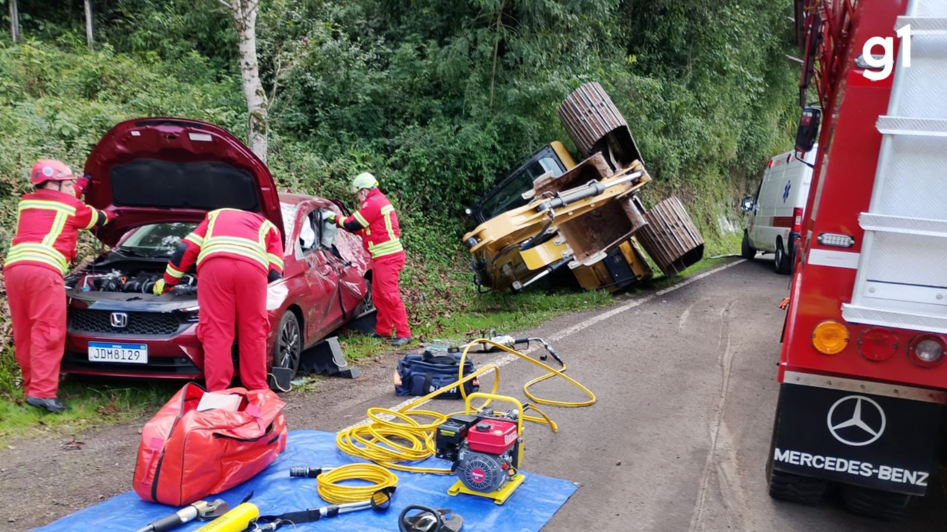 Retroescavadeira cai de caminhão e atinge carro na BR-116