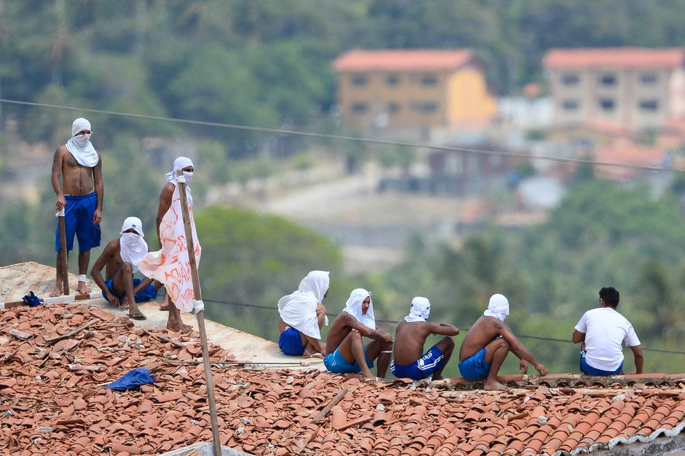 Presos são vistos no telhado da penitenciária de Alcaçuz, no Rio Grande do Norte, durante rebelião — Foto: Andressa Anholete/AFP