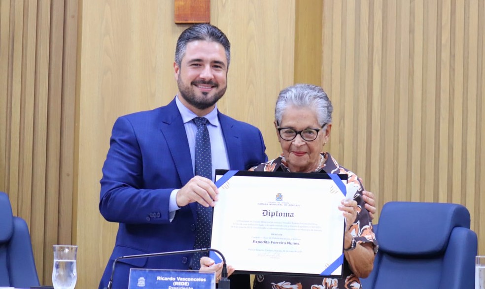Presidente da Câmara de Aracaju, Ricardo Vasconcelos entrega o título à Expedita Ferreira — Foto: CMA