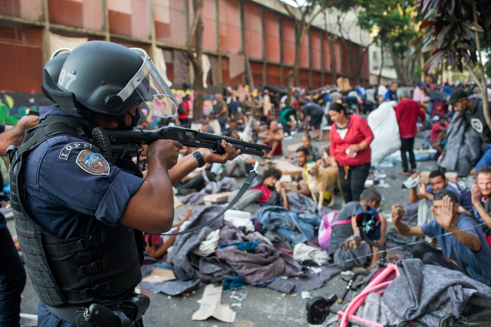 Policial aponta arma para usuários de droga durante operação da Polícia Civil na Cracolândia, em São Paulo, em 2022 — Foto: TIAGO QUEIROZ/ESTADÃO CONTEÚDO