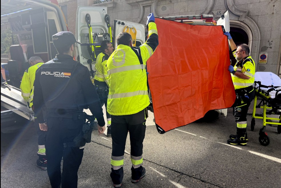 Agentes do serviço de emergências de Madri protegem ambulância durante atendimento a político catalão Alejo Quadras-Vidal, baleado no rosto em uma rua de Madri, na Espanha, 9 de novembro de 2023. — Foto: Serviço de emergências de Madri via AP