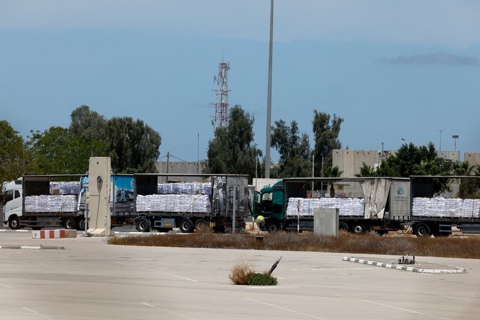 Caminhões carregando ajuda humanitária parados no lado israelense da passagem de Kerem Shalom, na fronteira com a Faixa de Gaza, em 20 de maio de 2025. — Foto: REUTERS/Amir Cohen