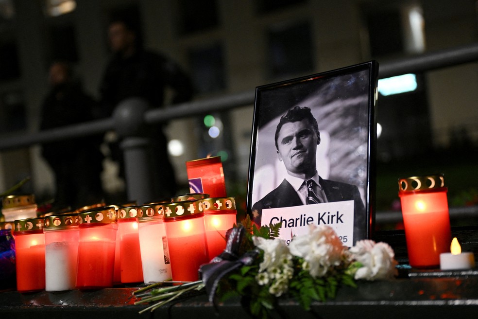 Flores e velas são deixadas em frente a uma foto de homenagem a Kirk — Foto: Annegret Hilse/Reuters