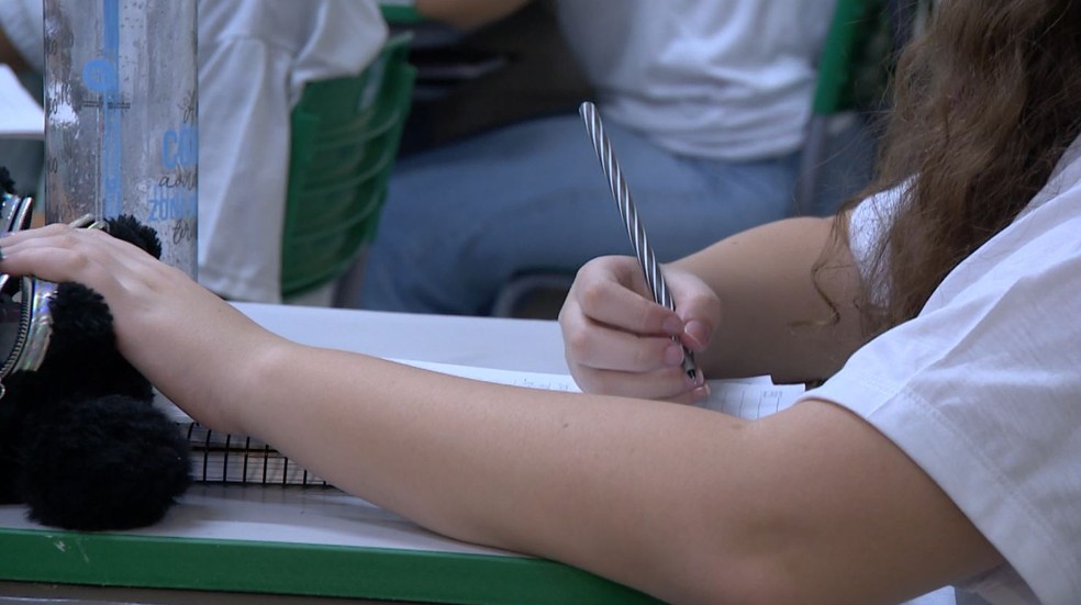 Menina escrevendo em ambiente escolar, sem identificação. — Foto: Reprodução EPTV