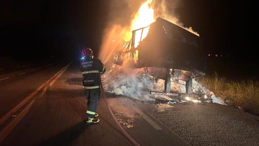 Bombeiro com mangueira tentando apagar o fogo na carreta — Foto: Sargento Gonçalves/Corpo de Bombeiros de Mato Grosso