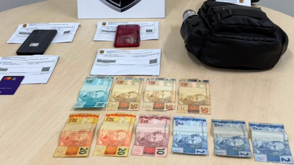 Dinheiro, celulares e bolsa apreendidos com suspeito de cometer chacina no bairro São Jorge, em Manaus — Foto: Divulgação/PC-AM
