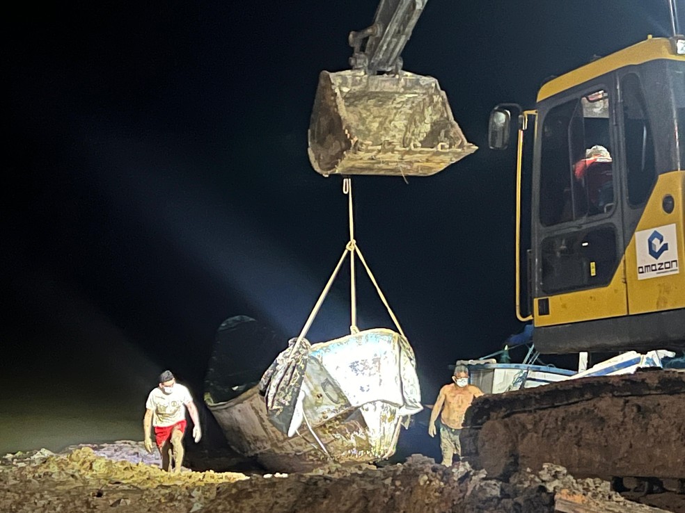 Barco com corpos no Pará: Máquina faz retirada de embarcação da margem de rio para caminhão levar até IML em Bragança — Foto: Fábia Sepêda/TV Liberal