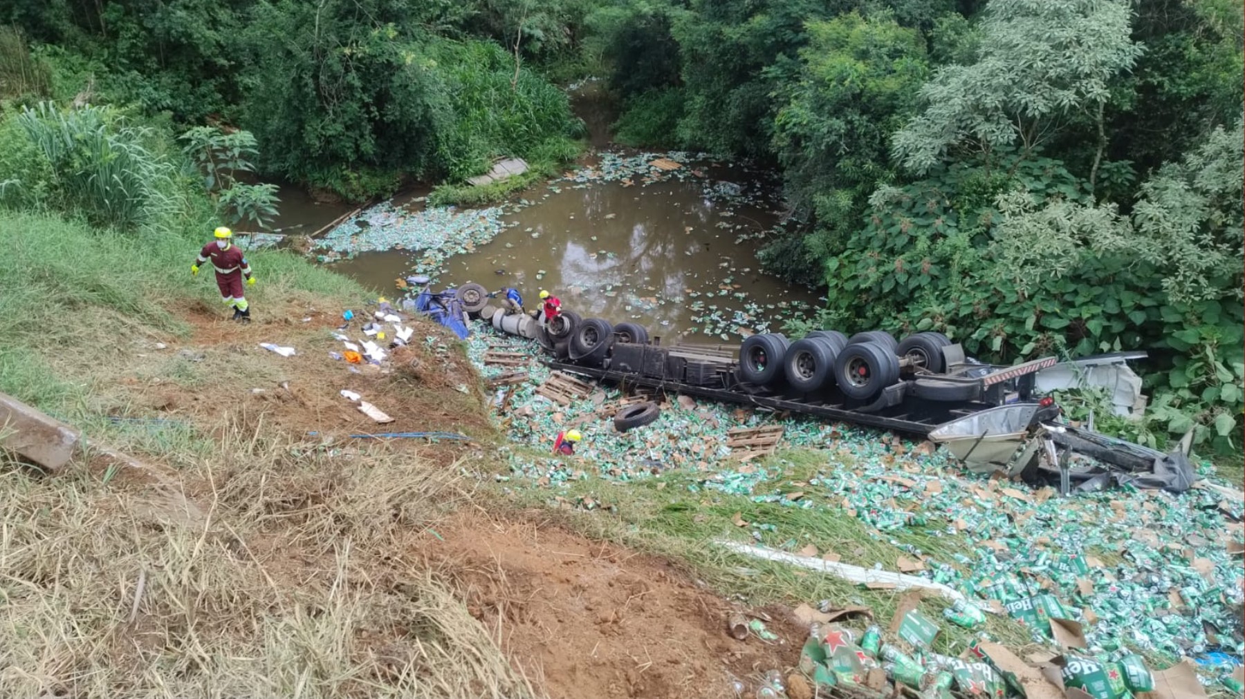 Caminhoneiro morre após tombar e cair em rio, e 15 pessoas são presas por saquear carga de cerveja durante resgate do corpo da vítima, no PR