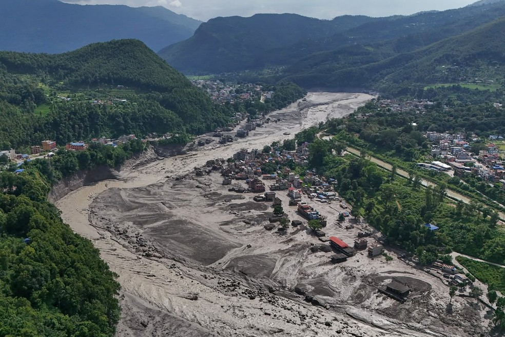 Casas danificadas à beira do rio Trishuli, que está tomado por destroços após uma enxurrada no distrito de Nuwakot, no Nepal — Foto: Niranjan Shrestha / AP