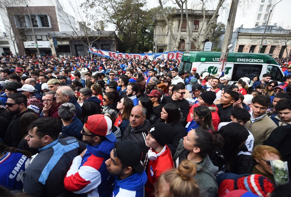 Torcedores e admiradores de Juan Izquierdo tentando entrar no velório para prestar última homenagem — Foto: Dante Fernandez / AFP