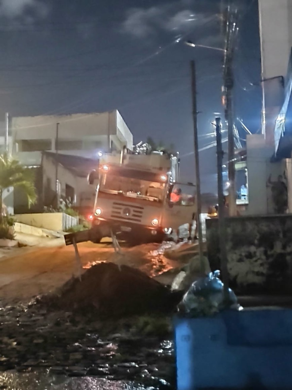Carro de coleta de lixo fica preso em buraco no bairro Nordeste, em Natal — Foto: Cedida